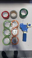 Overview of all six tape rolls still wrapped plus Uline dispenser