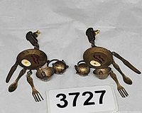 Pair of brass tone breakfast motif earrings displayed side by side