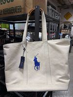 Front view of natural canvas tote with blue polo logo
