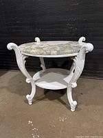 angled view showing full table, carved legs, marble top