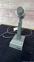 Front view showing complete Shure microphone on stand with attached cable