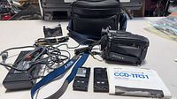 Complete kit laid out: camcorder, batteries, AC adapter, cables, bag, manual