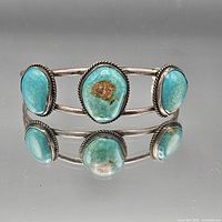 Front view showing three turquoise cabochons and overall design