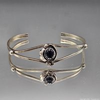 Front angled view of sterling silver double-band cuff bracelet showing black onyx cabochon setting and open ends