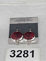 Front view of earrings on display card showing overall design and material