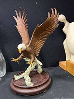 Full view of bald eagle sculpture on wooden base
