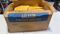 Open Uline box filled with gold #0 bubble mailers
