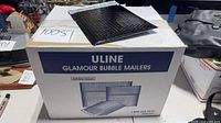Closed box of Uline Glamour Bubble Mailers with one mailer displayed on top