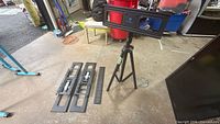 Overall view of tripod stand with mounting plate and separate brackets on floor
