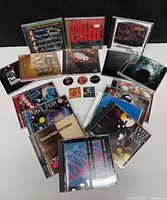 All sixteen CDs arranged with cases and five pins centred