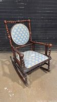 Full view of rocking chair showing wood frame, twist details, upholstery
