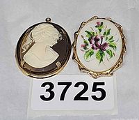 Front view of cameo pendant and floral dress clip