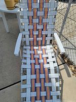 Front view of aluminum folding lawn chair showing rainbow webbing and adjustable frame