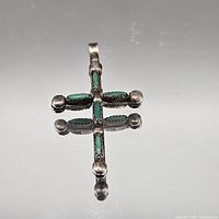 front view of silver cross pendant with turquoise inlay