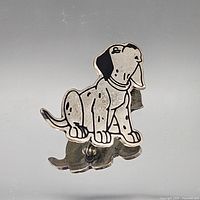 Front view of sterling silver dog brooch with black enamel accents