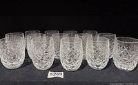 Front angled view of all 14 crystal tumblers showing cut pattern and clarity