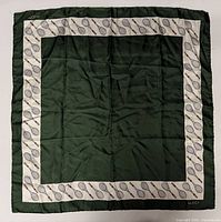Full view of green silk scarf with cream tennis racket border