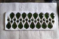 Tray containing 16 emerald green glass chandelier drops with connectors