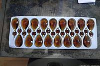 Tray holding 17 honey amber teardrop prisms with beads and stems