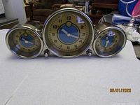 Front view of triple dial metal desk clock