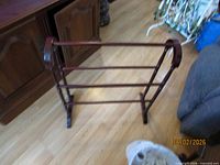 Angle view of mahogany blanket rack showing rails and side supports