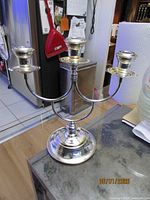 Full view of silver-plated three-arm candle holder