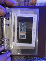 Binder page showing 60¢ blue Canadian revenue stamp serial 161888 on annotated card within plastic sleeve