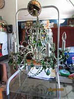 Full view of chandelier hanging on frame, showing six arms, bobeches, prisms
