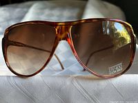 Front view of Britalia sunglasses showing tortoiseshell aviator frame and amber gradient lenses with UV400 CR39 sticker