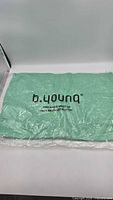 Cardigan folded inside clear b.young branded recycled plastic bag