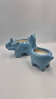 Elephant and alpaca shaped blue ceramic candles side view