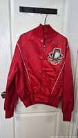 Full front view of red Coca-Cola satin jacket on hanger