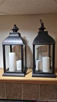 Front view of both lanterns showing design and included candles