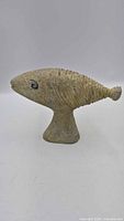 Full profile view of stone fish sculpture