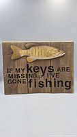 Full view of wooden fishing sign with fish relief and text