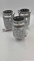 Three galvanized metal night lights with plugs visible
