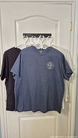 Three Levi's tees hanging: navy, dark, white