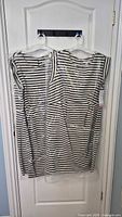 Both striped maternity dresses on hangers inside plastic film