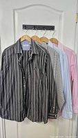 Four shirts hung on door showing front patterns and colors