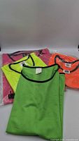 Group of green, yellow, orange and pink mesh bibs