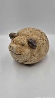 Front angled view of textured stone-look pig sculpture