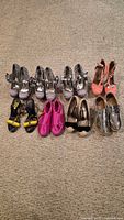 All eight pairs of shoes lined on carpet