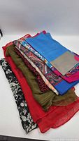 Stack of eight scarves showing variety of colors and patterns