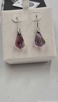 Front view of pink teardrop crystal earrings on display box