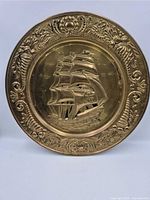 Front view showing full brass plaque, sailing ship relief and ornate border