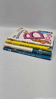 Stack of four hardcover children's books showing spines and covers
