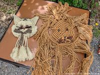 Both macramé animal wall hangings on display table