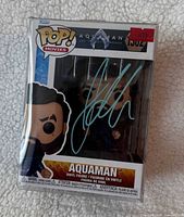 Front view of boxed Funko Pop! Aquaman #1302 with teal Jason Momoa signature visible