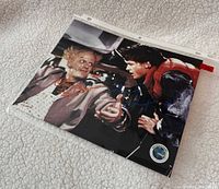 Full view of signed photo in sleeve showing scene with Doc Brown and Marty McFly