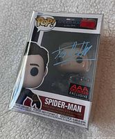 Front view showing Spider-Man Pop #1073 with Tom Holland blue signature and AAA Anime Exclusive sticker